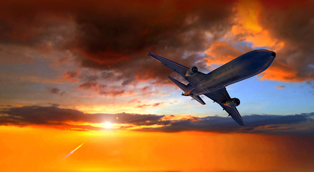 Flygplan som flyger i solnedgången.