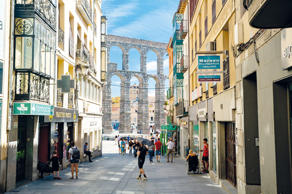 Gata i Segovia med akvedukten i bakgrunden.