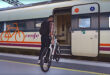 En cyklist lastar in sin cykel i ett tåg från Renfe, Spanien.