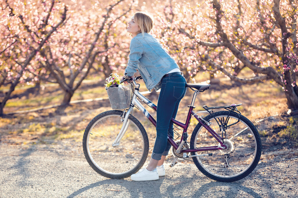 Kvinna på cykel en vacker vårdag.